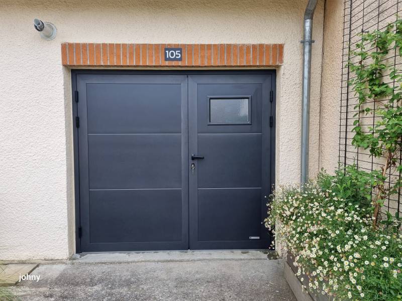 Une porte de garage battante avec des vantaux inégaux pour un accès piéton facilité et un plus grand espace de rangement à l'intérieur du garage 