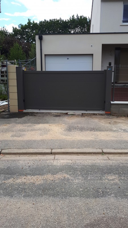 Installer un portail coulissant motorisé en aluminium gris quartz 7039 et un portillon sur une maison moderne à Bois-Guillaume près de Rouen (76) avec visiophone