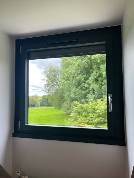 ETANEL Image d'une maison rénovée à Saint-Paër avec fenêtres et volets roulants installés.