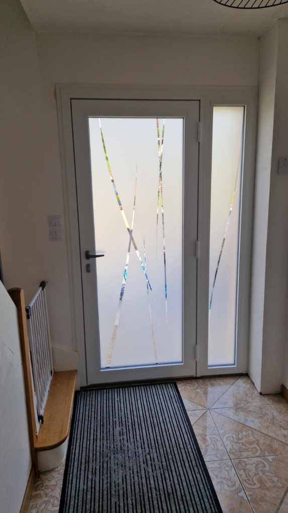Une porte d’entrée de grande dimension avec un panneau vitré personnalisé en verre trempé 