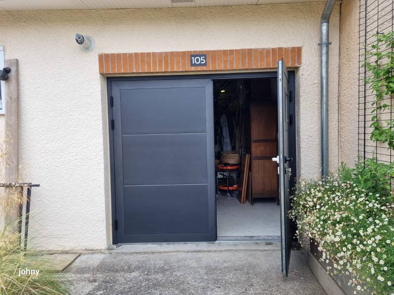 Une porte de garage battante avec des vantaux inégaux pour un accès piéton facilité et un plus grand espace de rangement à l'intérieur du garage