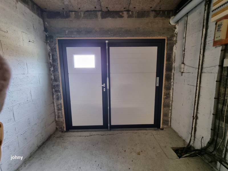 Une porte de garage battante avec des vantaux inégaux pour un accès piéton facilité et un plus grand espace de rangement à l'intérieur du garage