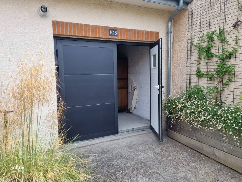 Une porte de garage battante avec des vantaux inégaux pour un accès piéton facilité et un plus grand espace de rangement à l'intérieur du garage